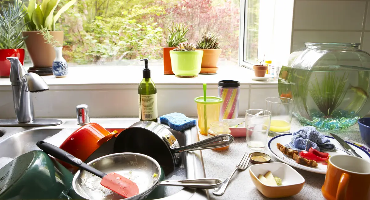 dirty dishing piled up in kitchen sink