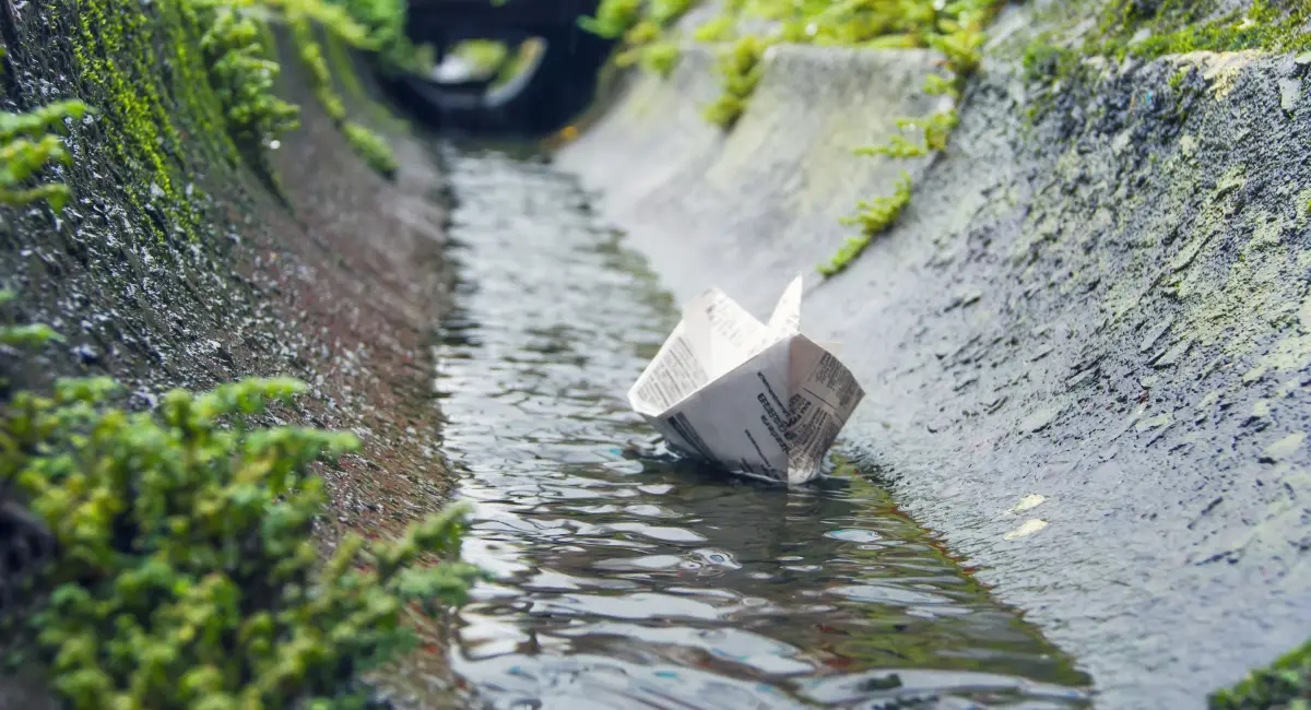 paper boat floating on standing water in sewer